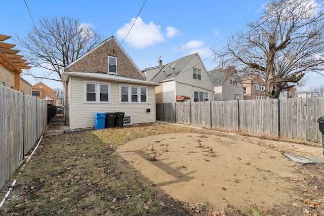 rear view of property with a fenced backyard