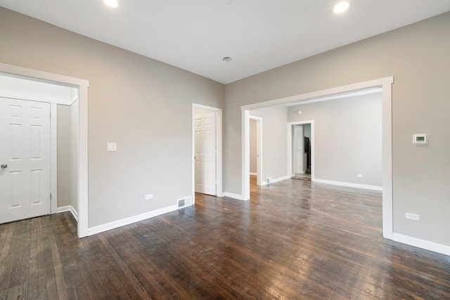 empty room with baseboards, visible vents, dark wood finished floors, and recessed lighting