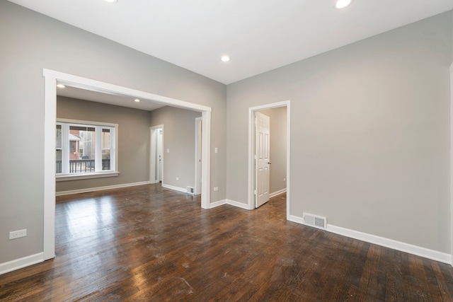 empty room featuring recessed lighting, dark wood-style flooring, visible vents, and baseboards