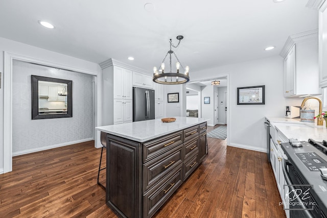 kitchen featuring dark wood-style floors, baseboards, white cabinets, and refrigerator