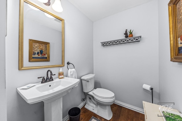 bathroom with wood finished floors, toilet, and baseboards