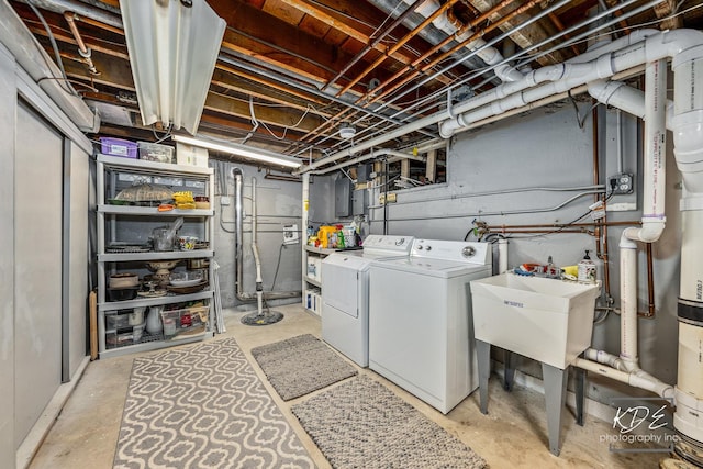 laundry room featuring laundry area, separate washer and dryer, and a sink