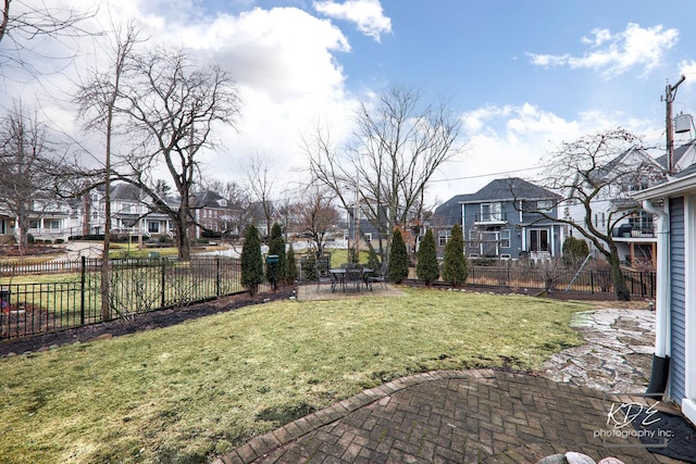 view of yard with a patio, a fenced backyard, and a residential view