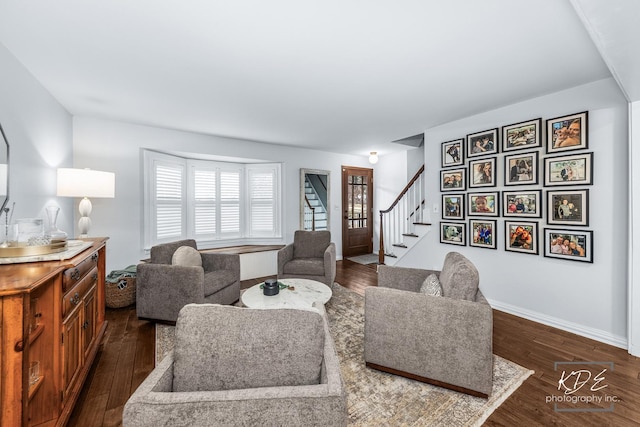 living area with dark wood-style floors, stairway, and baseboards