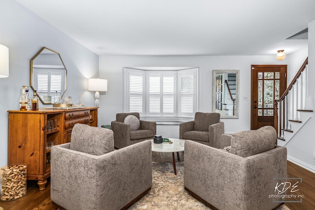 living room with stairs, baseboards, wood finished floors, and a healthy amount of sunlight