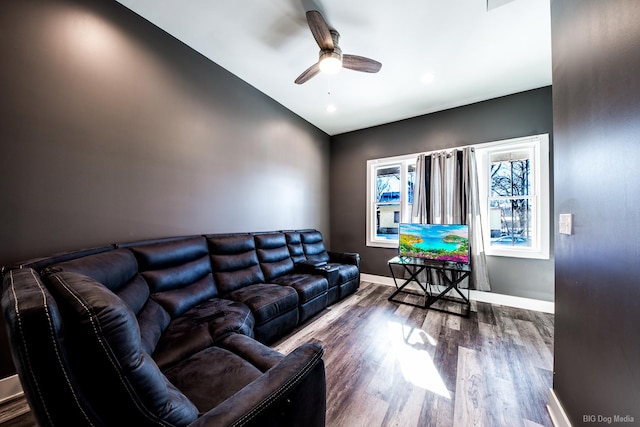 living room featuring a ceiling fan, baseboards, and wood finished floors