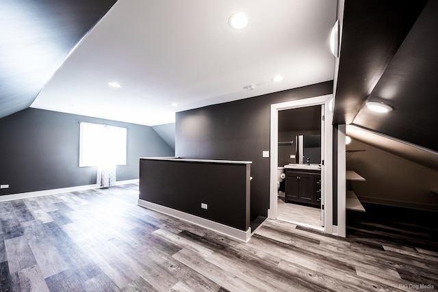 bonus room with lofted ceiling, baseboards, and wood finished floors