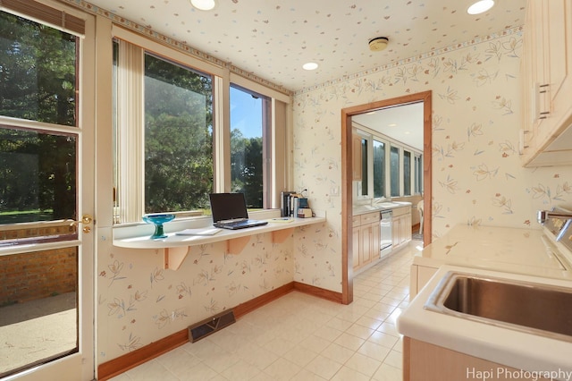 interior space featuring visible vents, a sink, dishwasher, baseboards, and wallpapered walls