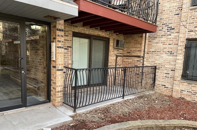 doorway to property with brick siding and a balcony