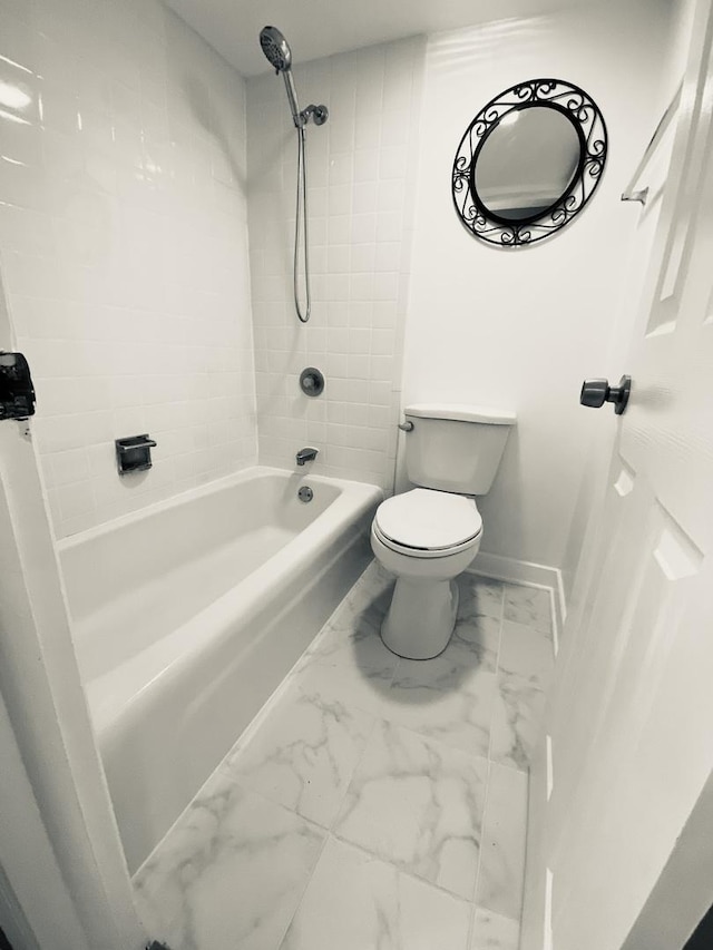 bathroom with marble finish floor, baseboards, toilet, and shower / bathtub combination