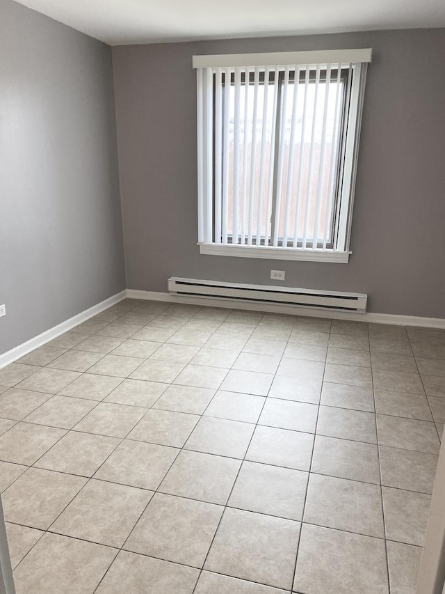 empty room featuring a baseboard radiator and baseboards