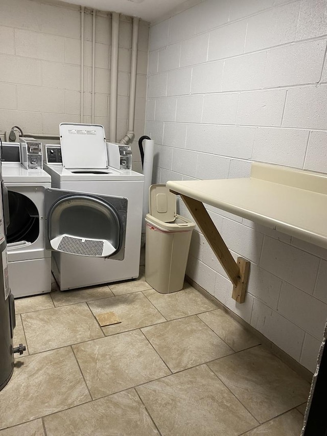 community laundry room with washing machine and dryer and concrete block wall