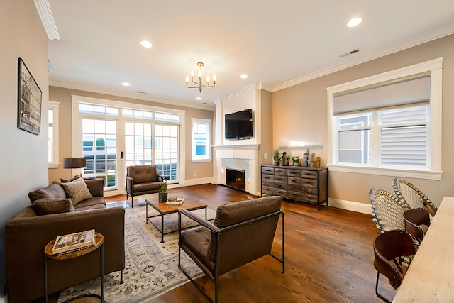 living room with visible vents, ornamental molding, a lit fireplace, and wood finished floors