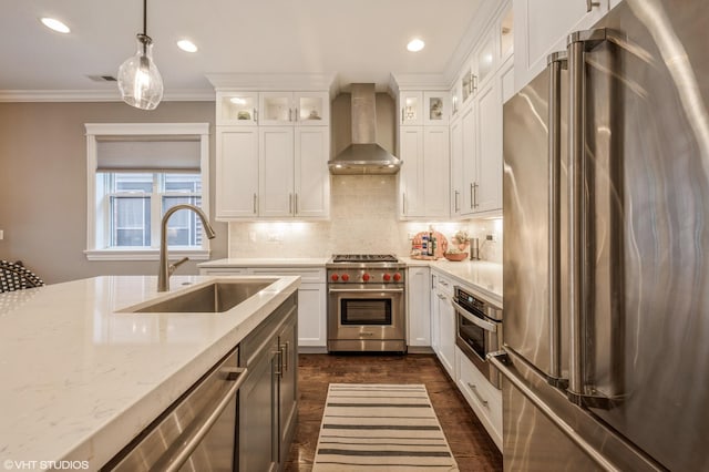 kitchen with ornamental molding, a sink, tasteful backsplash, stainless steel appliances, and wall chimney range hood