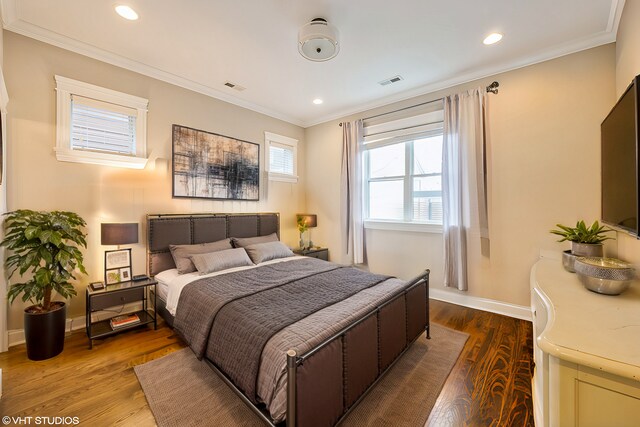 bedroom featuring visible vents, crown molding, baseboards, recessed lighting, and wood finished floors