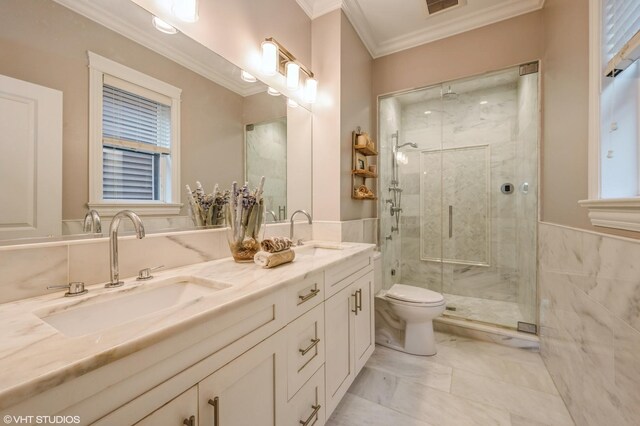 bathroom featuring crown molding, toilet, a stall shower, and a sink