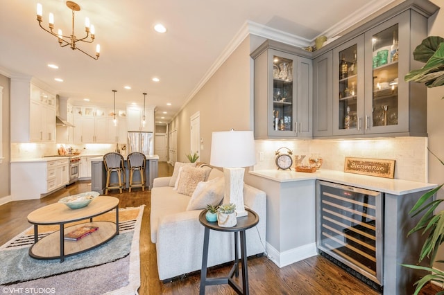 living area featuring recessed lighting, beverage cooler, dark wood-style flooring, and ornamental molding