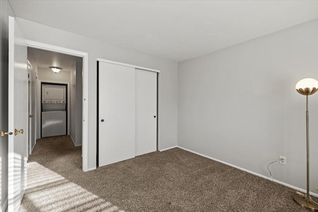 unfurnished bedroom with stacked washer and dryer, carpet floors, and a closet