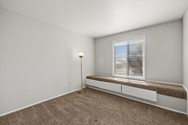 unfurnished room featuring carpet and baseboards