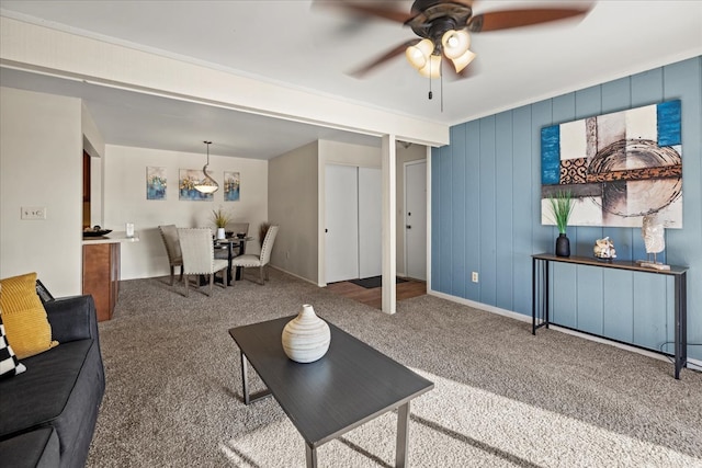 living area with carpet and ceiling fan