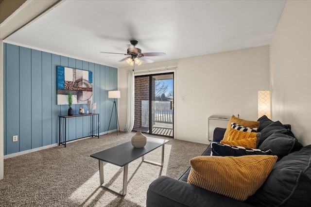 carpeted living area with a ceiling fan and baseboards