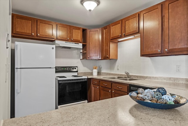 kitchen with tasteful backsplash, freestanding refrigerator, under cabinet range hood, a sink, and range with electric stovetop