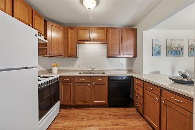 kitchen with white appliances, light wood finished floors, a sink, and light countertops