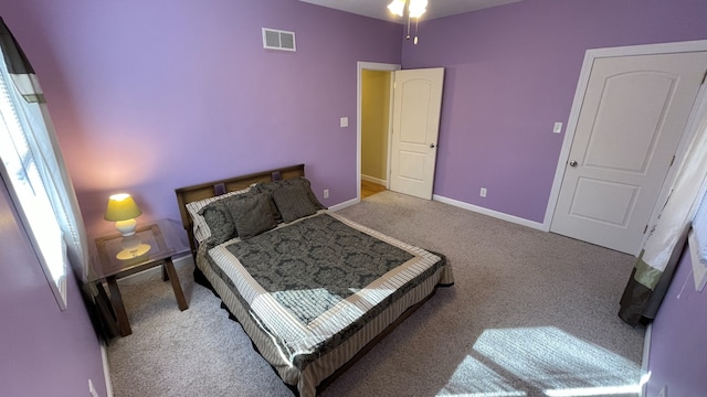 carpeted bedroom featuring visible vents and baseboards