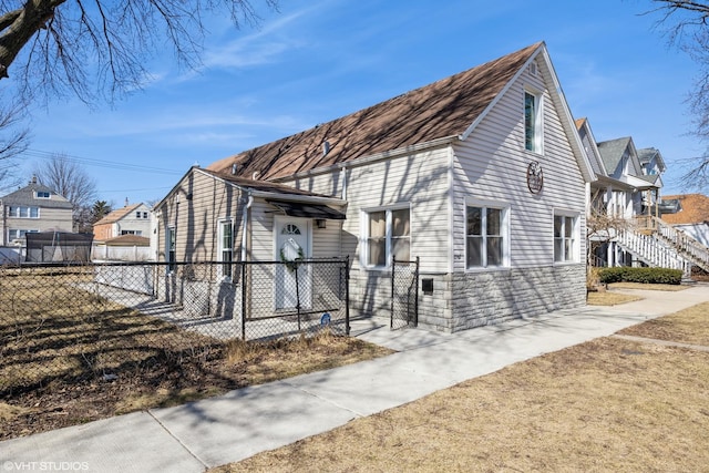 view of home's exterior with stone siding and fence private yard