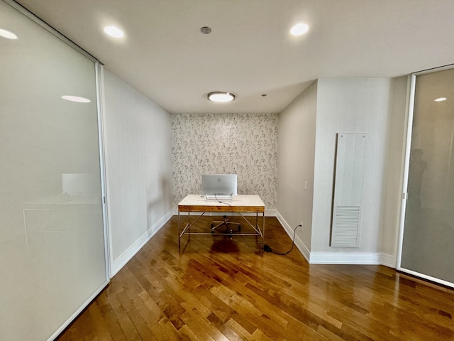 unfurnished office with wallpapered walls, baseboards, visible vents, wood finished floors, and recessed lighting