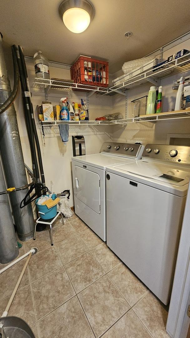 laundry area featuring laundry area, washing machine and dryer, and light tile patterned flooring