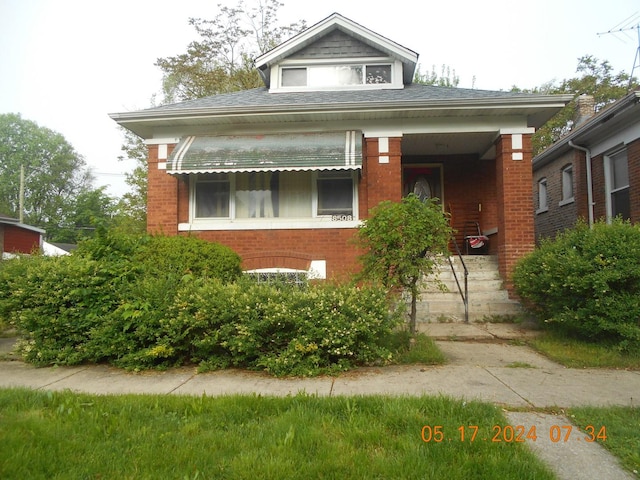 bungalow-style house with brick siding