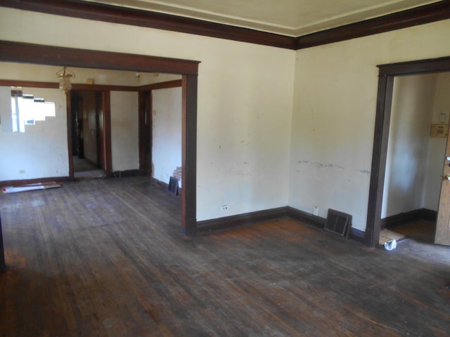 unfurnished room with dark wood-style floors, visible vents, and baseboards