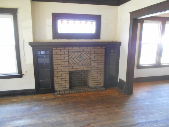 details featuring a brick fireplace, baseboards, and wood finished floors