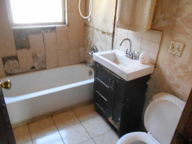 bathroom with a tub to relax in, tasteful backsplash, toilet, vanity, and tile patterned floors