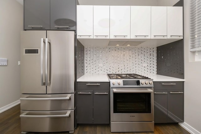 kitchen featuring stainless steel appliances, tasteful backsplash, gray cabinets, and white cabinetry