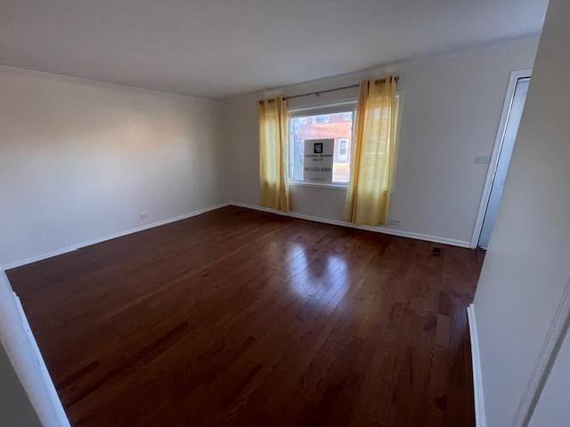 spare room with dark wood-style floors and baseboards