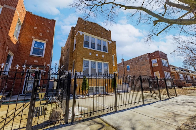 view of front facade featuring brick siding and a fenced front yard