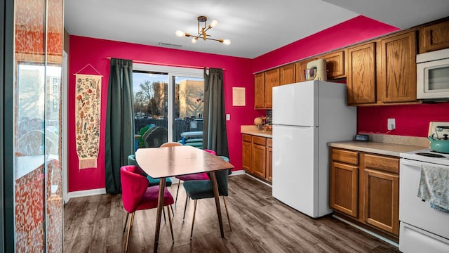 kitchen featuring dark wood-style floors, white appliances, brown cabinetry, and visible vents