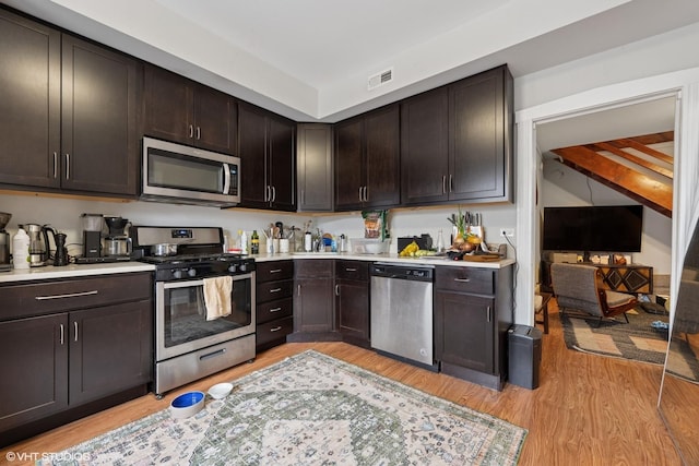 2531 W Lyndale St, Chicago, IL 60647 - kitchen featuring appliances with stainless steel finishes, light countertops, dark brown cabinets, and light wood finished floors