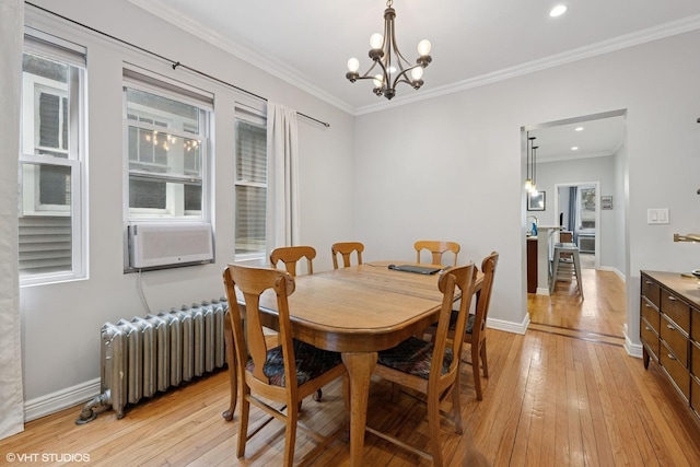 2531 W Lyndale St, Chicago, IL 60647 - dining room featuring radiator heating unit, light wood-style floors, a chandelier, cooling unit, and ornamental molding