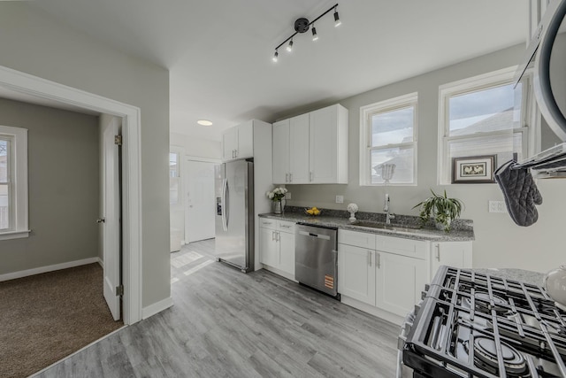 kitchen with a healthy amount of sunlight, white cabinetry, and stainless steel appliances