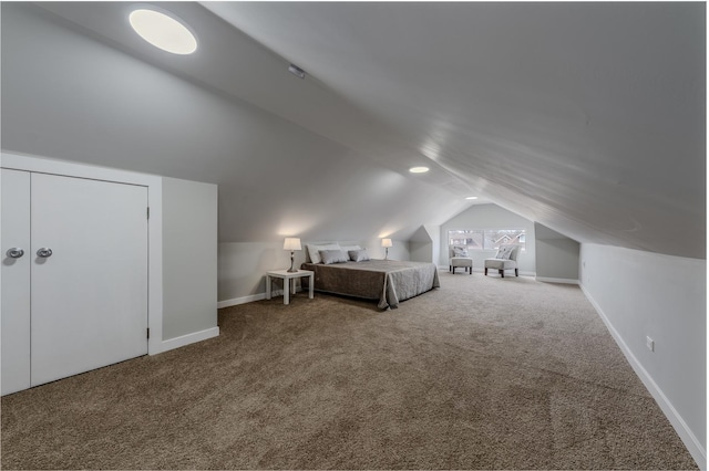 unfurnished bedroom with lofted ceiling, carpet, and baseboards