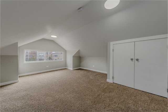 bonus room featuring vaulted ceiling, carpet flooring, and baseboards