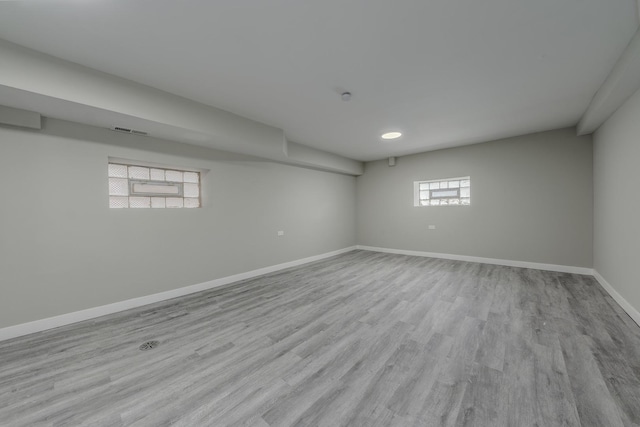 empty room with visible vents, baseboards, and wood finished floors