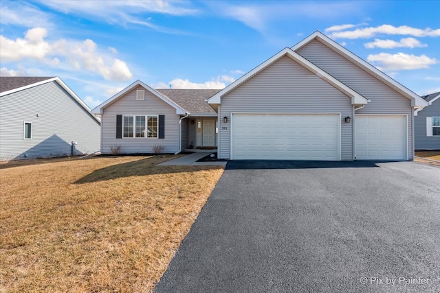 ranch-style house featuring an attached garage, aphalt driveway, and a front lawn