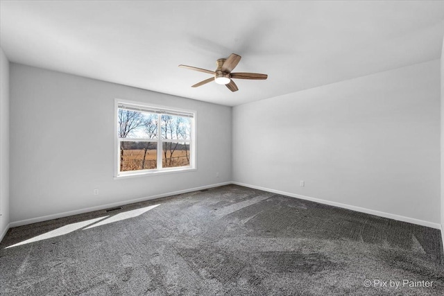 carpeted spare room with baseboards, visible vents, and a ceiling fan