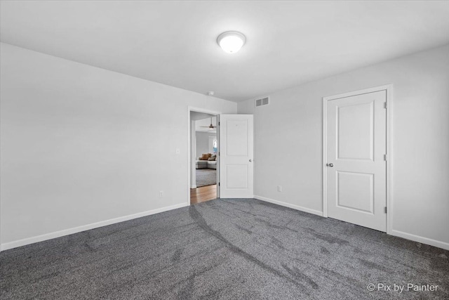 unfurnished bedroom with carpet floors, visible vents, and baseboards