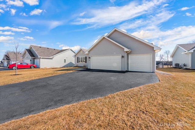 ranch-style home with driveway, an attached garage, a residential view, and a front yard