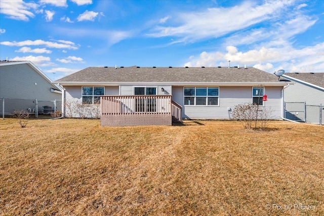 rear view of property with a yard, a deck, and fence